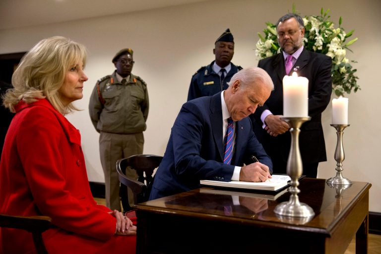 Vice President Joe Biden, accompanied by his wife Jill, signs a condolence book inside the South African Embassy in Washington, Monday, Dec. 9, 2013, as they paid their respects to former South African President Nelson Mandela. During the visit Biden said that the former president was, 