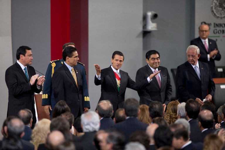 Mexico's President Enrique Pena Nieto, center, acknowledges the crowd during his second state-of-the-nation address inside the National Palace in Mexico City, Tuesday, Sept. 2, 2014.  (AP Photo/Eduardo Verdugo)