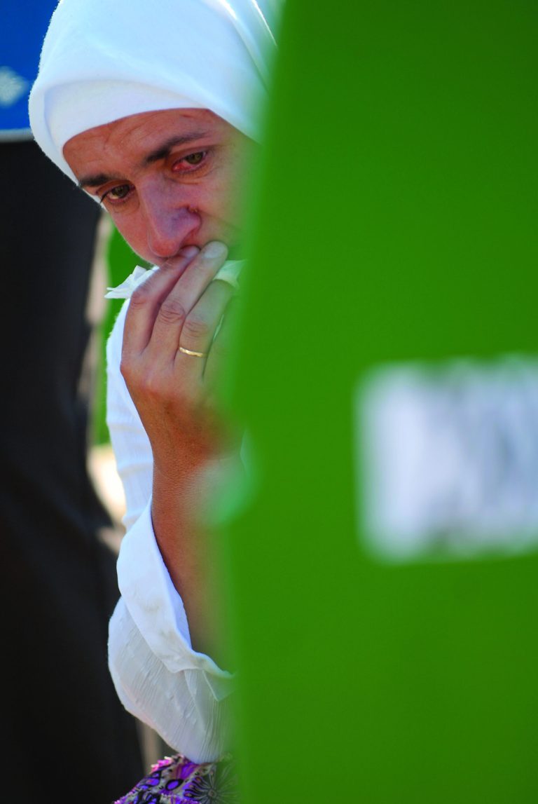 A Bosnian Muslim woman weeps near the grave of her relative among the graves of Srebrenica victims at the Memorial Cemetery in Potocari, near Srebrenica, 160 kms northeast of Sarajevo, Bosnia, Wednesday, July 11, 2012. Thousands gathered in the cemetery for the mass burial of 520 bodies, marking the 17th anniversary of the Srebrenica massacre. (AP Photo/Sulejman Omerbasic)