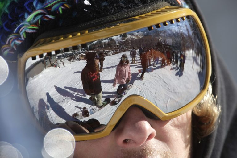   FILE - This Nov. 13, 2012 file photo shows the reflection of skiers as they gather in line for the chair lift during the first day of their ski season at the Brighton Ski Resort in the Wasatch Range, in Utah. A weeklong storm clearing northern Utah on Friday left ski resorts with more than 3 feet of fresh snow, marking a big change from the dry holidays of last year. (AP Photo/Rick Bowmer, File)  