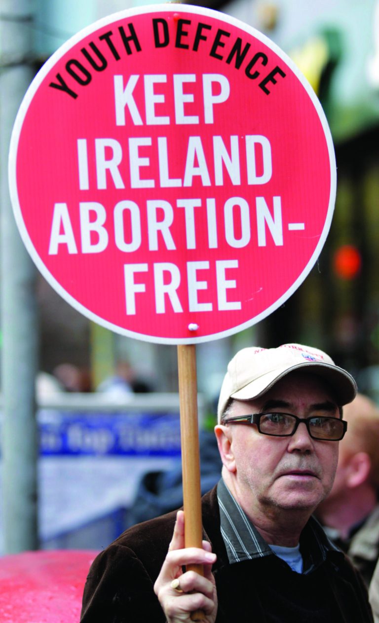 A protester opposed to abortion holds a placard outside the Marie Stopes clinic in Belfast, Northern Ireland, Thursday, 18, 2012. The first abortion clinic on the island of Ireland has opened in Belfast, sparking protests by Christian conservatives from both the Catholic and Protestant sides of Northern Ireland's divide. The Marie Stopes center plans to offer the abortion pill to women less than nine weeks pregnant _ but only if doctors determine they're at risk of death or long-term health damage from their pregnancy. That's the law in both Northern Ireland and the Republic of Ireland, where abortion is otherwise illegal. (AP Photo/Peter Morrison)