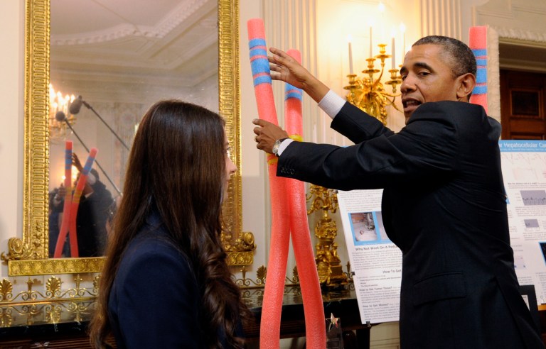 President Barack Obama talks with Elana Simon, 18, of New York City, about her cancer research project that is part of the 2014 White House Science Fair exhibit on display in the State Dining Room of the White House in Washington, Tuesday, May 27, 2014. Simon, at age 12, was diagnosed with fibrolamellar hepatocellular carcinoma, a little-known form of cancer that affects the liver. After surviving the disease, she now helps scientists research the genetics behind it. Obama was celebrating the student winners of a broad range of science, technology, engineering and math (STEM) competitions from across the country. (AP Photo/Susan Walsh)