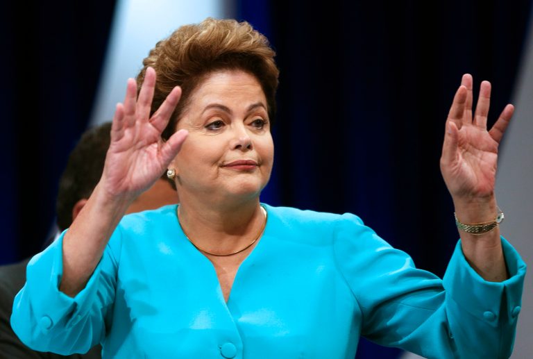Brazil's President Dilma Rousseff, who is running for re-election with the Workers Party, waves to photographers during a commercial break as she attends a presidential candidate debate in Sao Paulo, Brazil, Thursday, Oct. 16, 2014. Rousseff will face Aecio Neves, candidate with the Brazilian Social Democracy Party, in a presidential runoff on Sunday, Oct. 26. (AP Photo/Andre Penner)