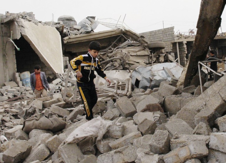   A boy walks in rubble at the scene of a car bomb attack in al-Mouafaqiyah, a village inhabited by families from the Shabak ethnic group, near the city of Mosul, 225 miles (360 kilometers) northwest of Baghdad, Iraq, Monday, Dec. 17, 2012. Three car bomb explosions in Iraqâs north on Monday, killing and wounding scores of people, police said. (AP Photo)  