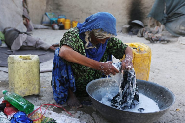 A woman washes clothing at a camp for internally displaced Afghans on World Refugee Day in Kabul, Afghanistan, Friday, June 20, 2014. The plight of millions of refugees everywhere is marked Friday on World Refugee Day. The United Nations refugee agency says that at the end of last year, more than 50 million people have been forced from their homes worldwide, the highest figure of displaced since World War II. (AP Photo/Rahmat Gul)