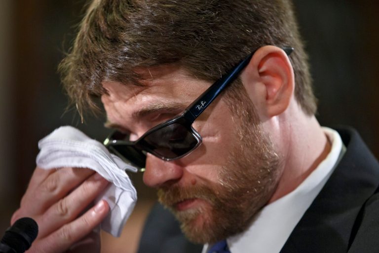 Travis Fugate, a member of the Kentucky National Guard who was blinded by an IED attack in Iraq, wipes his eyes as he testifies on Capitol Hill in Washington, Thursday, My 29, 2014, before the House Veterans Affairs subcommittee on Oversight & Investigations as the panel examines inadequacies in the Veterans Administration's treatment of visually-impaired veterans. (AP Photo/J. Scott Applewhite)