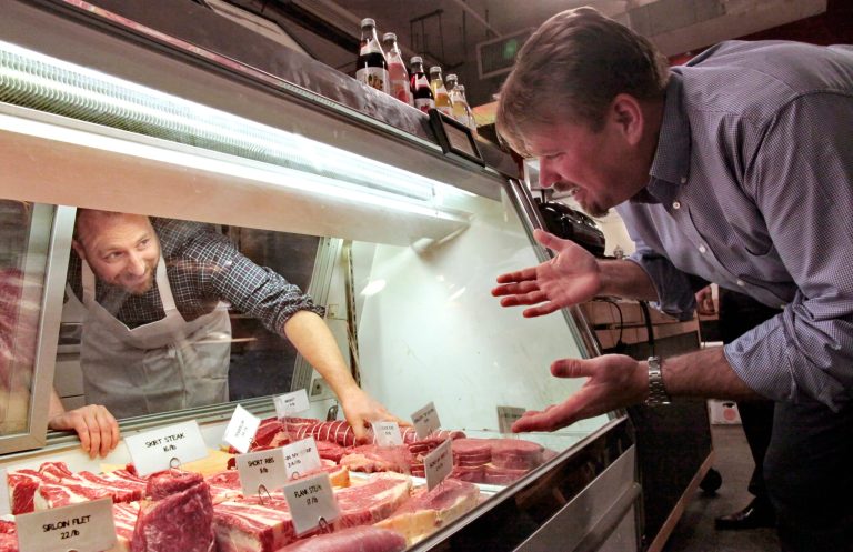   In this May 30, 2012 photo, Michael Phillips, Jamestown Properties Chief Executive Officer, right, visits Jacob Dickson, owner of Dickson's Farmstand Meats, a Chelsea Market butchery, at Chelsea Market in New York. One hundred years after the introduction of the Oreo, the complex that was once the former home to Nabisco is slated for an expansion many neighborhood residents oppose. (AP Photo/Bebeto Matthews)  