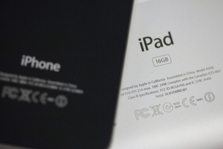   The back of an iPhone 4 and IPad 3 are displayed for a photographer in New York, Thursday, Dec. 6, 2012. Apple CEO Tim Cook said Thursday the company will produce one of its existing lines of Mac computers in the United States next year. Like most consumer electronics companies, Apple forges agreements with contract manufacturers to assemble its products overseas. (AP Photo/Karly Domb Sadof)  