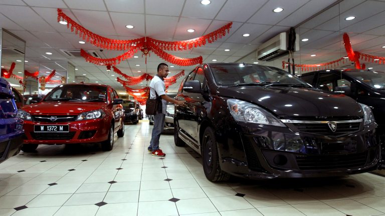 A man looks at a new car at a car showroom in Kuala Lumpur, Malaysia, Monday, Jan. 20, 2014. Malaysia's government unveiled Monday a new auto policy, offering incentives and easing curbs on the production of small, energy-efficient cars as it vies for investment with neighboring rivals Thailand and Indonesia. (AP Photo/Daniel Chan)