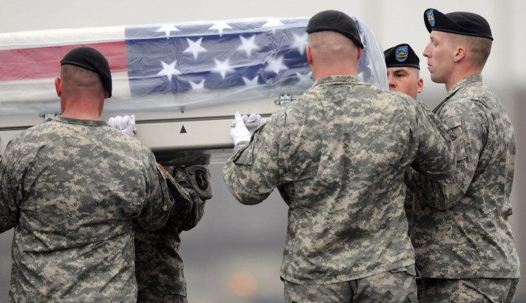 An Army carry team moves a transfer case containing the remains of Staff Sgt. Ofren Arrechaga at Dover Air Force Base, Del. Thursday, March 31, 2011. His widow, Seana Arrechaga, said photos from her husband's funeral have circulated the internet when Trump and other politicians publicly comment that the NFL protests are disrespectful to American troops. (AP Photo/Steve Ruark)