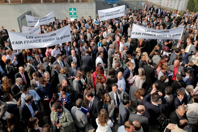 Air France workers gather in front of the company headquarters as they demonstrate against the pilots strike, in Roissy, outside Paris, Wednesday, Sept. 24, 2014. Air France-KLM says it isn't ready to abandon a plan to transfer activities to a low-cost carrier, contradicting a government minister's claim. France's junior minister for transport, Alain Vidalies, said on RMC radio Wednesday that Air France was withdrawing the plan in the face a protracted strike by pilots. Banners read, 'Air France workers against the strike'. (AP Photo/Christophe Ena)