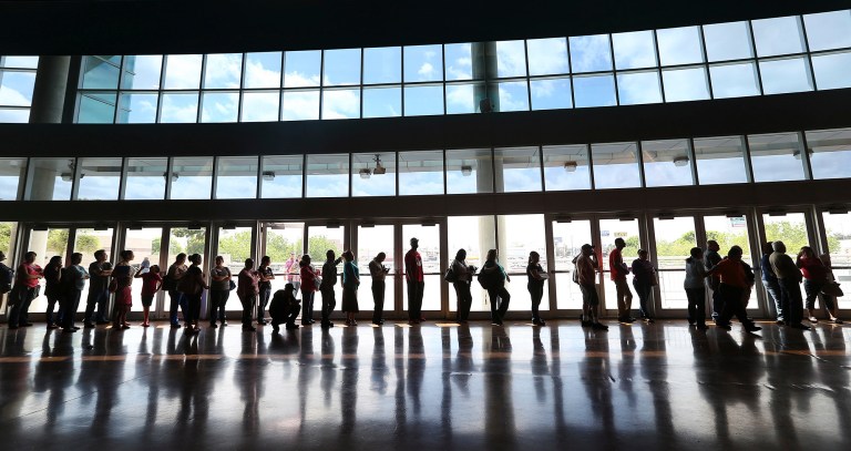 People line up to enroll for health insurance at the Alamodome in San Antonio, Texas, on March 31. President Obama's health care law has overcome its early botched rollout to sign up more than 7 million Americans, the White House announced Tuesday. (AP Photo/San Antonio Express-News, Jerry Lara)