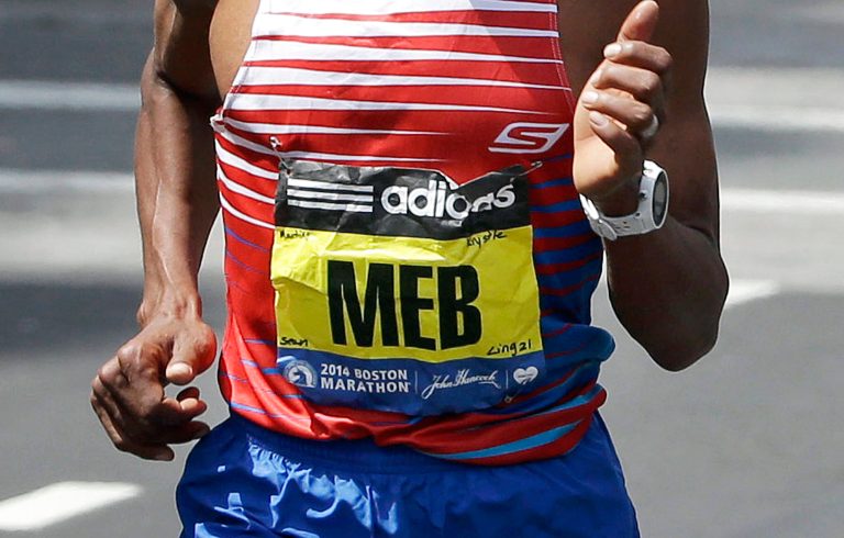 Meb Keflezighi, of San Diego, Calif., runs during the 118th Boston Marathon with the names of those killed in the 2013 bombings, and the MIT officer allegedly slain by the bombing suspects, on his bib, Monday, April 21, 2014, in Boston. Martin Richard, Krystle Campbell and Lu Lingzi, were killed in the bombings, while MIT officer Sean Collier was allegedly shot to death by the bombing suspects. (AP Photo/Steven Senne)