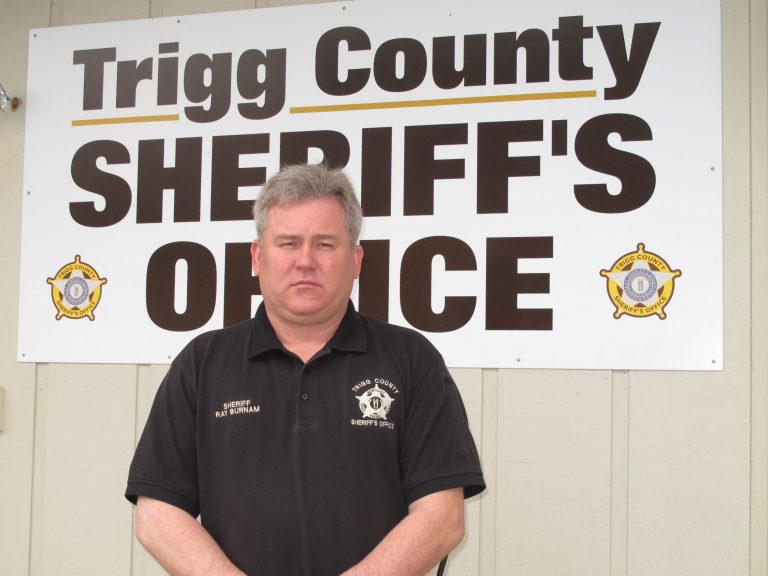  In this Tuesday, Dec. 4, 2012, photo, Trigg County Sheriff Ray Burnam stands in front of the sheriffâs department in Cadiz, Ky. When Burnam offered $1,000 of his own money as a reward for information leading to a conviction in three unsolved murder cases in western Kentucky county, law enforcement issued a court order demanding Burnam turn over his findings in one case and claimed he had gone 