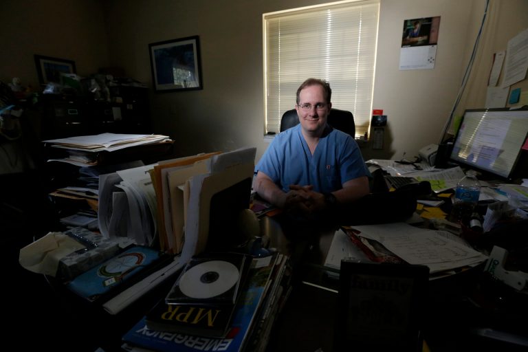In this photograph taken Friday, Oct. 17, 2014, William Gluckman, president of FastER Urgent Care, poses for The Associated Press in his facility in Morris Plains, N.J. Word that a second Dallas nurse caught the ebola disease from a patient has put the spotlight on weak spots in the U.S. health care system. But it's not just hospital emergency rooms that are on the front lines, thousands of round-the-clock clinics across the country are also possible first points of contact _ though they are not equipped to treat such a serious illness nor do they have isolation units. The clinics are scrambling to prepare their staff while also trying to get the message out that anyone who suspects they may have the virus should go to the hospital _ not an urgent care facility. (AP Photo/Julio Cortez)