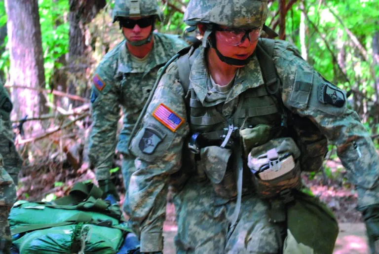 FILE - In a May 9, 2012 file photo, Capt. Sara Rodriguez, 26, of the 101st Airborne Division, carries a litter of sandbags during the Expert Field Medical Badge training at Fort Campbell, Ky. The Pentagon is lifting its ban on women serving in combat, opening hundreds of thousands of front-line positions and potentially elite commando jobs after generations of limits on their service, defense officials said Wednesday, Jan. 23, 2013. (AP Photo/Kristin M. Hall, File)