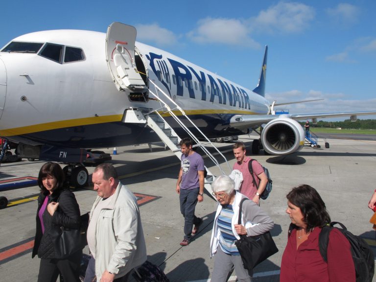 In this photo taken on Sept. 21, 2014, passengers exit a Ryanair flight at Dublin Airport.  Ryanair says it plans to carry an extra 1 million passengers this year and has raised its profits outlook on the back of wide-ranging service improvements that have boosted sales and filled more aircraft. The Dublin-based carrier told its annual general meeting Thursday that it plans to carry 87 million passengers in this fiscal year, better than its previous forecast of 86 million, and record net profits at or close to 650 million euros ($825 million), the top of its previously guided range. (AP Photo/Shawn Pogatchnik)