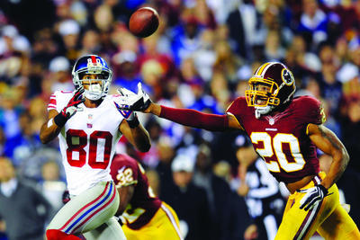 Redskins defensive back Cedric Griffin (20) keeps up the pressure on New York Giants wide receiver Victor Cruz (80) during Monday night's game. (AP Photo/Nick Wass)