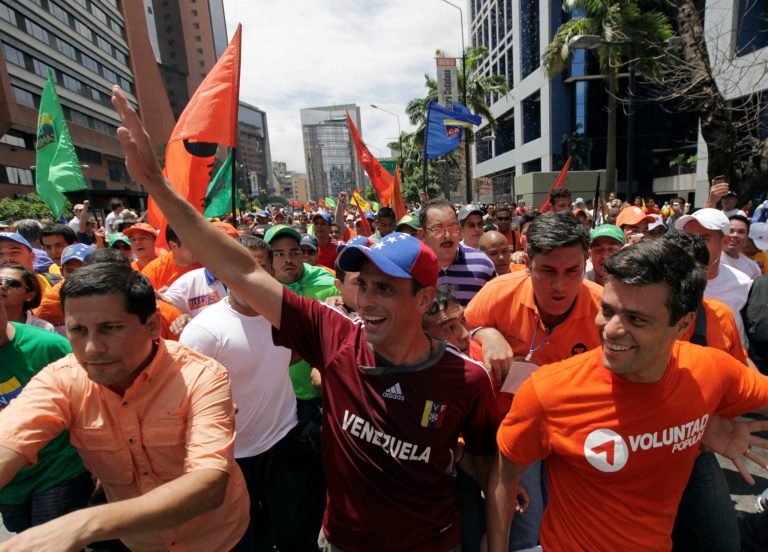   Surrounded by supporters, opposition presidential candidate Henrique Capriles, center, gestures during a march before registering his candidacy for the presidency in Caracas, Venezuela, Sunday, June 10, 2012. Capriles will face Venezuela's President Hugo Chavez in the presidential elections scheduled for Oct. 7. (AP Photo/Fernando Llano)  