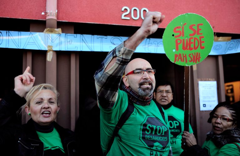 Members of the Mortgage Victims' Platform (PAH) react after an eviction was stopped in Barcelona, Spain, Wednesday, Jan. 29, 2014. Spain's National Statistics Agency says the unemployment rate for the fourth quarter of 2013 edged up slightly, leaving it stuck at the sky-high level of 26 percent and that the number of unemployed stood at a rounded 5.9 million people. Government officials say Spain's sluggish economy is stabilized and on track for job growth but economists predict it will take years to bring the jobless rate down to a more tolerable level. The banner reads in Spanish: 