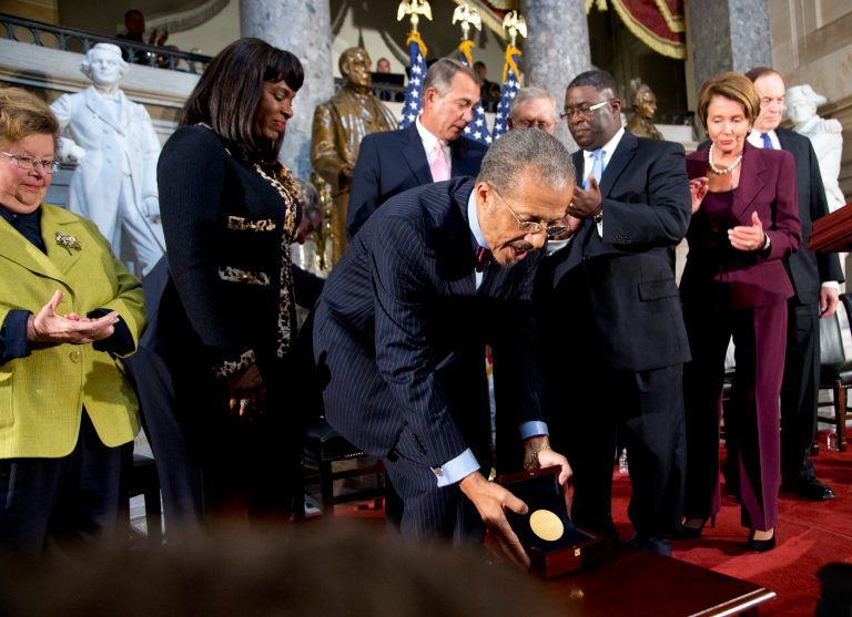   President and CEO of the Birmingham Civil Rights Institute Lawrence Pijeaux, front, lays on a table the Congressional Gold Medal posthumously awarded in honor of Addie Mae Collins, Denise McNair, Carole Robertson, and Cynthia Wesley, the four young black girls who lost their lives in the bombing of the 16th Street Baptist Church in Birmingham, Alabama, on September 15, 1963, presented by Speaker of the House Rep. John Boehner, back center, during a ceremony at the U.S. Capitol in Washington, Tuesday, Sept. 10, 2013. Others are, Sen. Barbara Mikulski, D-Md., from back left, Rep. Terri Sewell, D-Ala., Boehner, Senate Majority Leader Sen. Harry Reid, D-Nev., obscured, unidentified, House Democratic Leader Nancy Pelosi, D-Calif., and Sen. Richard Shelby, R-Ala. (AP Photo/Manuel Balce Ceneta)  