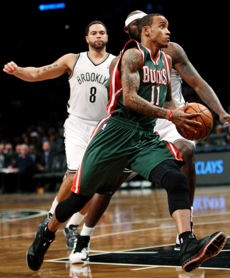   Milwaukee Bucks' Monta Ellis (11) drives to the basket past Brooklyn Nets' Deron Williams (8) and Reggie Evans during the first half of an NBA basketball game at Barclays Center, Sunday, Dec. 9, 2012, in New York. (AP Photo/Seth Wenig)  