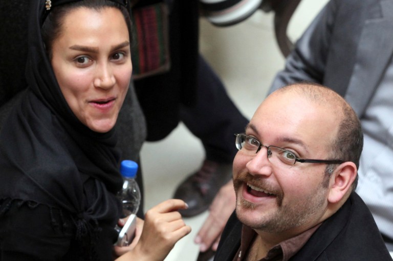 In this April 11, 2013 file photo, Jason Rezaian, right, an Iranian-American correspondent for the Washington Post, and his wife Yeganeh Salehi, an Iranian correspondent for the Abu Dhabi-based daily newspaper, The National, smile as they attend a presidential campaign of President Hassan Rouhani in Tehran, Iran. (AP Photo/Vahid Salemi, File)