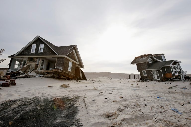   FILE - This Feb. 22,2013 file photo shows Two heavily damaged homes on the beach in Mantoloking, N.J., from Superstorm Sandy. Man-made global warming may decrease the likelihood of the already unusual steering currents that pushed Superstorm Sandy due west into New Jersey in a freak 1-in-700 year path, researchers report. While that may sound like the rare good climate change news, it's probably not, according to the study's authors, because they only looked at steering currents and other factors, including stronger storms, and sea level rise can and likely will outweigh any benefit from changing air patterns. The study is disputed by other scientists who have been vocal about the meteorological factors behind Sandy. (AP Photo/Mel Evans, File)  