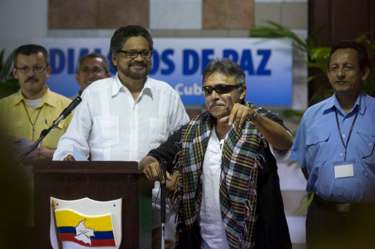 Jesus Santrich, member of the Revolutionary Armed Forces of Colombia (FARC), second from right, makes a joke before the start of a news conference, accompanied by fellow rebels Ivan Marquez, second from left, Yuri Camargo, far left, and Fidel Rondon, right, at the close of a round of peace talks with Colombia's government in Havana, Cuba, Friday, Aug. 22, 2014. Talks are expected to resume in September. (AP Photo/Ramon Espinosa)