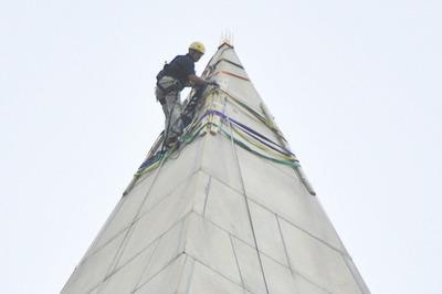 A team member of Wiss Janney and Elstner Disaster Assistance Team sets up grappling and repelling equipment on top of the Washington Memorial on Tuesday.-Graeme Jennings/Examiner