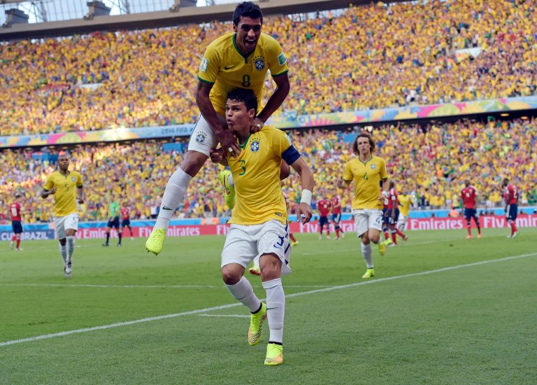 Brazil's Thiago Silva, bottom, celebrates with Paulinho after scoring the opening goal during the World Cup quarterfinal soccer match between Brazil and Colombia at the Arena Castelao in Fortaleza, Brazil, Friday, July 4, 2014. (AP Photo/Manu Fernandez)