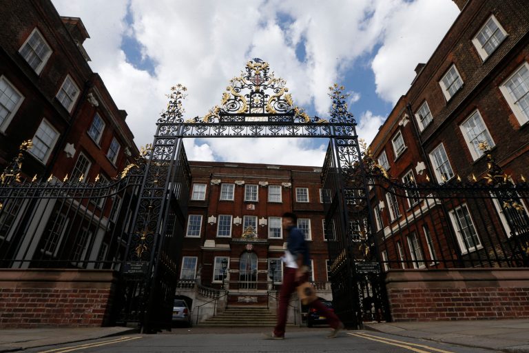 A man walks by the College of Arms in the City of London, Friday, May 9, 2014. The College of Arms, which has overseen noble titles and insignia since the 15th century, has ruled that same-sex married couples may join their heraldic symbols in the same way as heterosexual following the legalization of same-sex marriage in March. (AP Photo/Sang Tan)