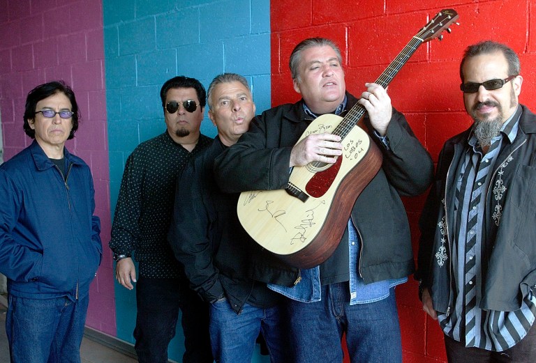   FILE - This April 7, 2004 file photo shows members of the band Los Lobos, from left, Louie Perez, Cesar Rosas, Conrad Lozano, David Hidalgo holding a guitar, and Steve Berlin posing for a photograph, in Los Angeles. They are the progenitors of Chicano rock ânâ roll, the first band that had the boldness, and some might say the naivetÃ©, to fuse punk rock with Mexican folk tunes. (AP Photo/Damian Dovarganes, file)  
