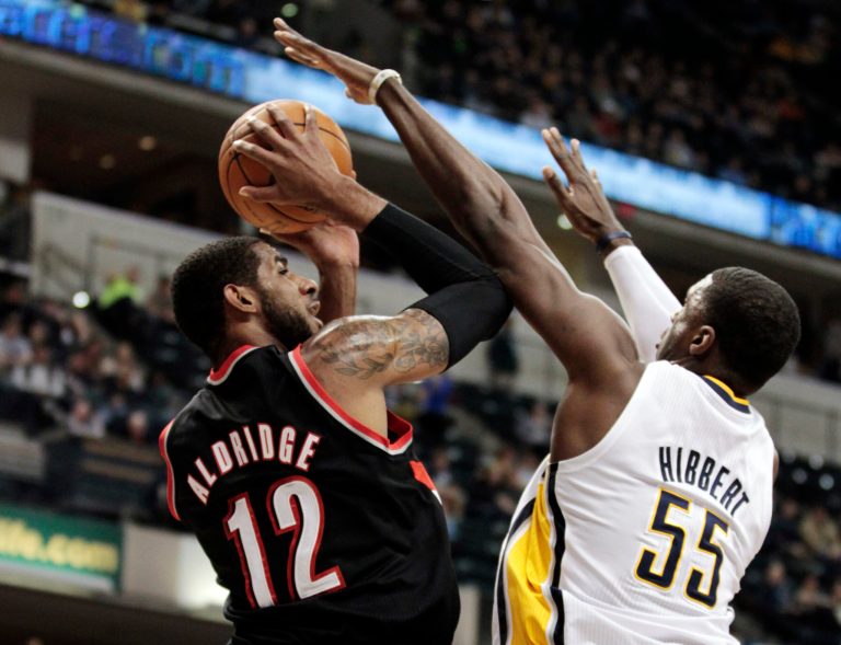   Portland Trail Blazers power forward LaMarcus Aldridge (12) shoots under pressure from Indiana Pacers center Roy Hibbert in the first half of an NBA basketball game in Indianapolis, Wednesday, Dec. 5, 2012. (AP Photo/Michael Conroy)  