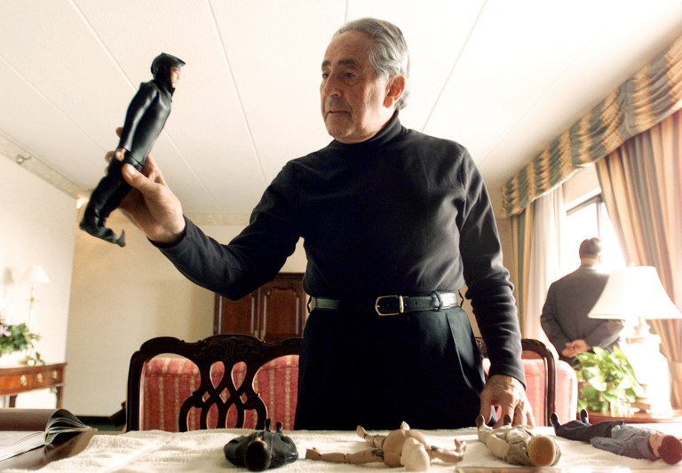 FILE - In this Jan. 30, 2003 file photo, G.I. Joe creator Don Levine holds up his original scuba diver G.I. Joe as other original prototypes lie on top of a table in Providence, R.I. Levine died of cancer early Thursday, May 22, 2014, at Home & Hospice Care of Rhode Island, said his wife, Nan. He was 86. (AP Photo/Victoria Arocho, File)