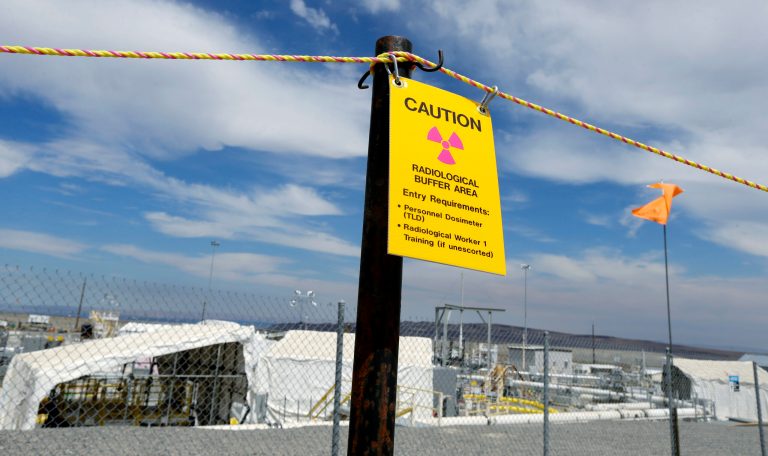 A sign warns of radioactivity near a wind direction flag indicator at the 