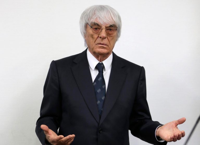 Formula One boss Bernie Ecclestone gestures as he arrives for his trial in the regional court in Munich, southern Germany, Tuesday, Aug.5, 2014. Ecclestone is charged with bribery and incitement to breach of trust 