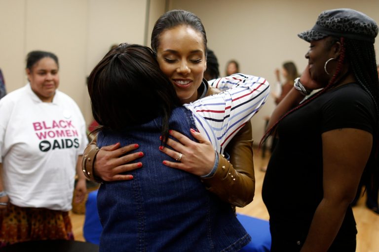 Grammy Award-winning singer Alicia Keys hugs HIV positive woman as she visits an HIV women's support group at United Medical Center in Washington, Monday, April 15, 2013. Keys is working with the Kaiser Family Foundation for 