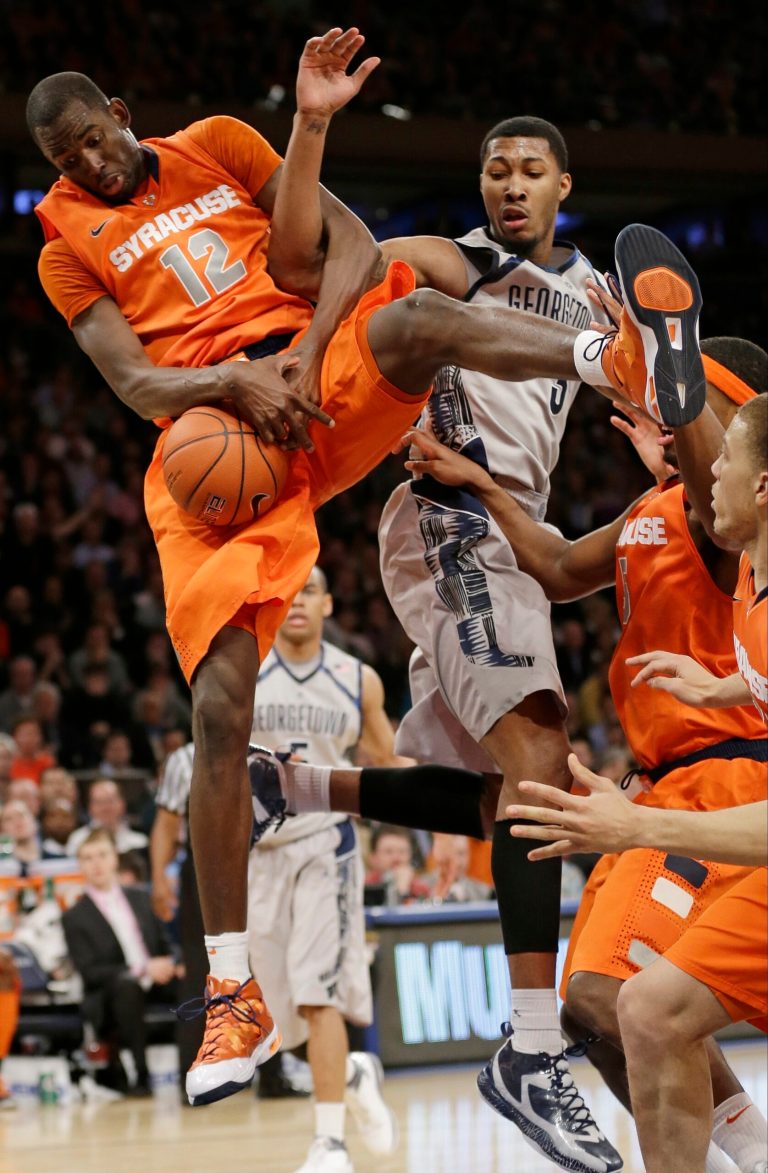 Frank Franklin II/AP
Syracuse's Baye Keita (12) and Georgetown's Mikael Hopkins (3) fight for control of the ball. Syracuse won the game 58-55.