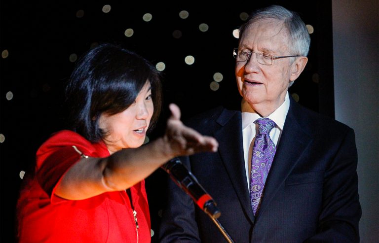 In this photo taken on Thursday, Aug. 21, 2014, U.S. Rep. Grace Meng, D-Queens,  and U.S. Sen. Harry Reid, D-Nev., take the stage during the Asian Chamber of Commerce's monthly lunch at the Gold Coast casino-hotel in Las Vegas. Reid, the Democratic Senate Majority Leader, is apologized Friday, for jokes he made about Asians during the luncheon(AP Photo/Las Vegas Review-Journal, Erik Verduzco) LAS VEGAS SUN OUT