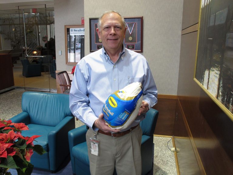   Cryovac executive Don Smith holds up a frozen turkey wrapped in one of his company's bags at the firm's plant in Duncan, S.C. on Thursday, Dec. 13, 2012. Fifty years ago Cryovac invented the bag that allowed for the long term cheap production and storage of turkeys at the plant in Duncan. (AP Photo/Jeffrey Collins)  