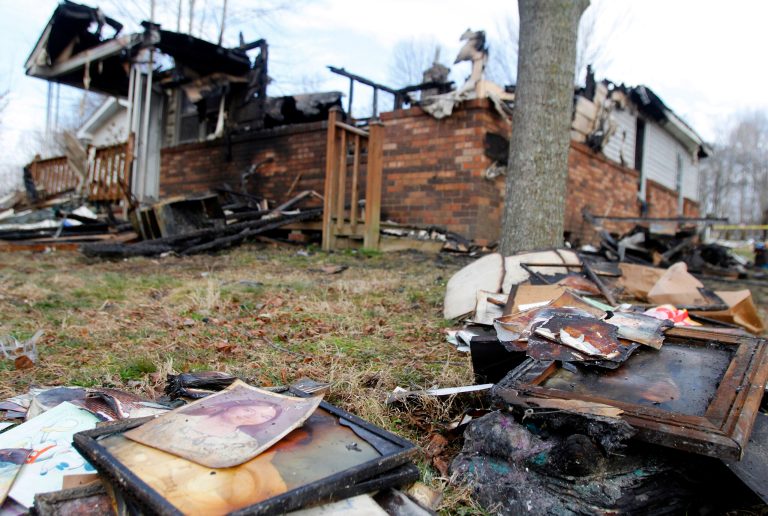 This Sunday, March 10, 2013 photo shows the charred remains of a home after a fire erupted, Saturday, March 9, 2013 in Gray, Ky, killing two adults and five children inside. (AP Photo/Lisa Norman-Hudson)
