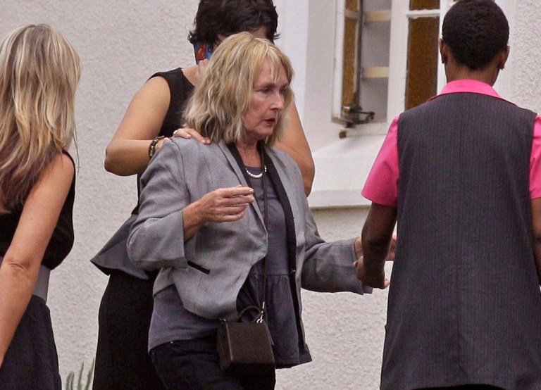 FILE - In this taken Feb. 19, 2013, file photo, June Steenkamp, center, the mother of Reeva Steenkamp, arrives for her funeral in Port Elizabeth, South Africa. The mother of Oscar Pistorius' slain girlfriend will attend the double-amputee Olympian's murder trial next month, Reeva Steenkamp's family said Tuesday, Feb. 11, 2014,  as the anniversary of the shooting death that shocked millions approaches. (AP Photo/Schalk van Zuydam, File)