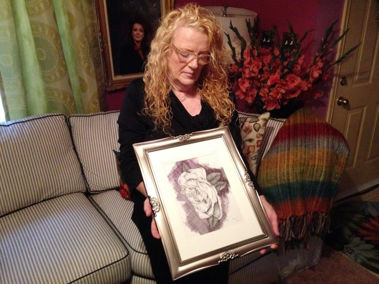 On Friday, Oct. 18, 2013, Joyce Jackson holds a drawing made by her son Bobby Gerald Bennett, in Dallas. Jackson says Bennett, who is a schizophrenic, wanted to take the drawing with him out of the house leading to an argument that caused her to call police Monday. Surveillance video from a neighbor's camera shows Bennett standing as two officers approach him. Seconds later, Officer Cardan Spencer fires at Bennet who now remains in a hospital intensive care unit. Dallas police have opened a criminal investigation and placed the officer on administrative leave indefinitely. (AP Photo/Nomaan Merchant)