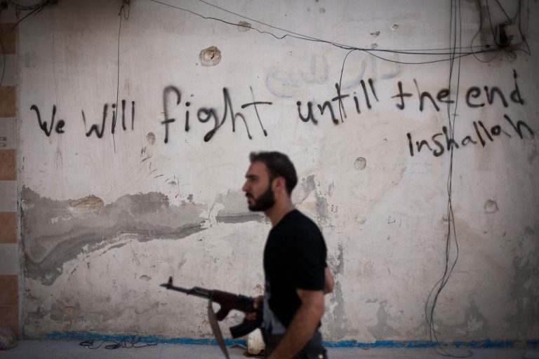 FILE - In this Monday, Sept. 10, 2012 file photo, a Free Syrian Army fighter walks through a street in Amariya district in Aleppo, Syria. The chaos unleashed by the Arab Spring has led to the rise of powerful militias -- including many Islamic extremist groups -- across a Middle East where many central governments have been exposed as weak. Some of the groups are allied with such governments, others are fighting to topple them and some -- like the Kurdish peshmerga in northern Iraq -- are seen as vital Western allies. All could prove to be major obstacles to bringing peace or stability to the troubled region. (AP Photo/ Manu Brabo, FIle)