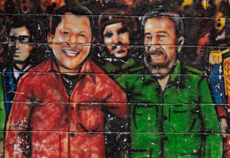   FILE - In this Feb. 22, 2012 file photo, a mural featuring Venezuela's President Hugo Chavez, left, and Cuba's Fidel Castro, adorns a wall in Caracas, Venezuela. Under Chavezâs leadership, Venezuela has sent billions of dollars a year to Cuba through trade and petro-aid, supplying about half of the islandâs energy needs at greatly subsidized rates. The Venezuelan president regularly calls Fidel Castro his ideological father and has followed much of the Communist legendâs governance and foreign relations playbook. (AP Photo/Ariana Cubillos, File)  