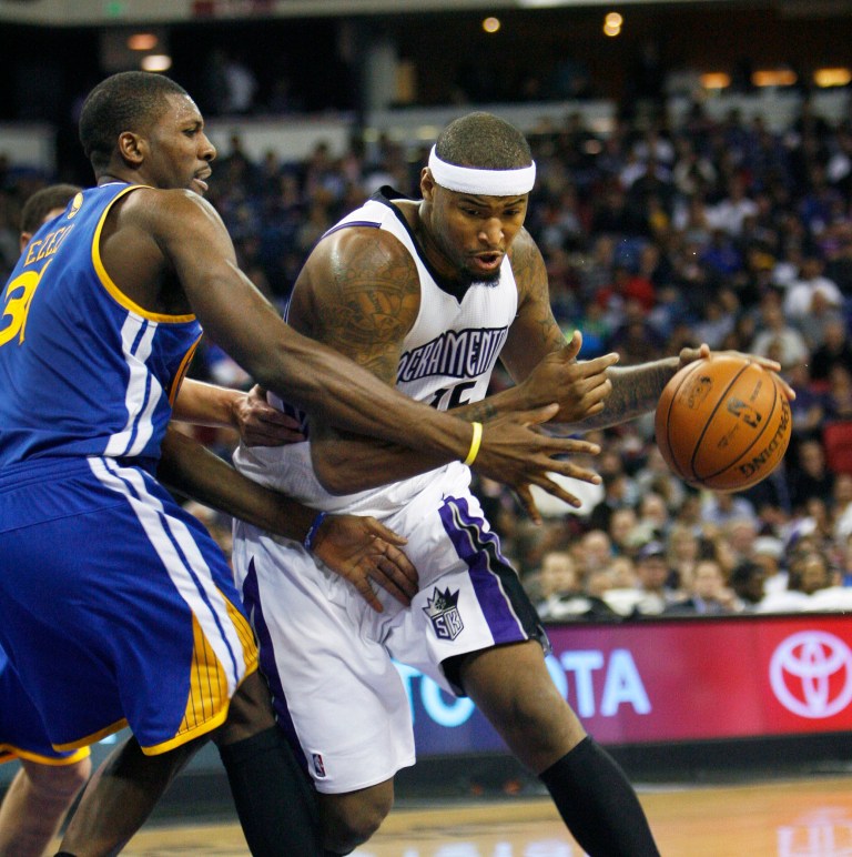   Sacramento Kings center DeMarcus Cousins, right, drives to the basket around Golden State Warriors defender Festus Ezeli during the second half of an NBA basketball game in Sacramento, Calif., on Wednesday, Dec. 19, 2012. The Kings won 131-127.(AP Photo/Steve Yeater)  