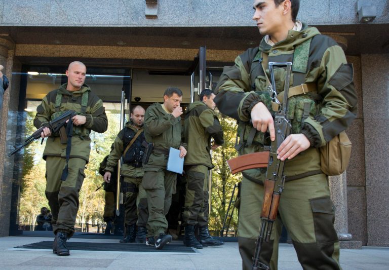 Alexander Zakharchenko, Prime Minister of the self proclaimed 'Donetsk People's Republic', centre,  surrounded by pro-Russian rebels, walks in the town of Donetsk, eastern Ukraine Saturday, Oct. 11, 2014. A pro-Russian rebel leader says they have signed a demarcation deal with the Ukrainian government which sees the Ukrainians give up several villages including the one next to a strategic airport. (AP Photo/Dmitry Lovetsky)