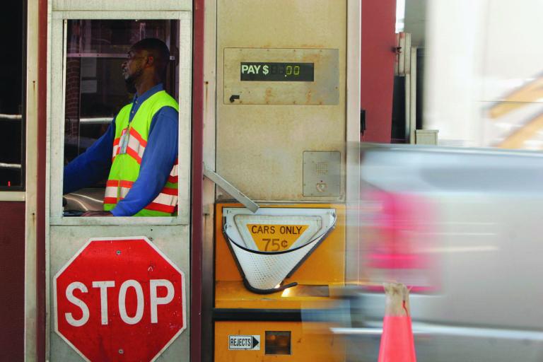 A toll booth collector works at the main toll plaza on the Dulles Toll Road in Northern Virginia.  The price of a round-trip ride could increase by $1 next year and go as high as $9 by 2015. (Examiner file)