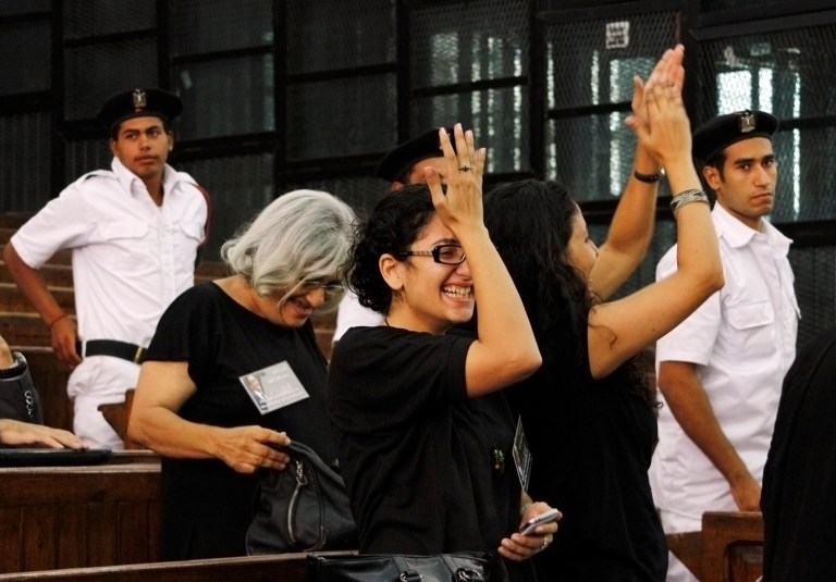 Prominent Egyptian blogger Alaa Abdel-Fattah's mother, Laila Soueif, a university professor who is an also an activist, background left, his sisters Sanaa Seif, wearing eyeglasses at center, and Mona Seif, at right, cheer after his release on bail at a courtroom in Cairo, Egypt, Monday, Sept. 15, 2014. Relatives say that Egypt's most prominent activist who is standing retrial after being sentenced to 15 years in prison for violating to the country's draconian protest law, has been released on bail. (AP Photo/Ravy Shaker, El Shorouk) EGYPT OUT